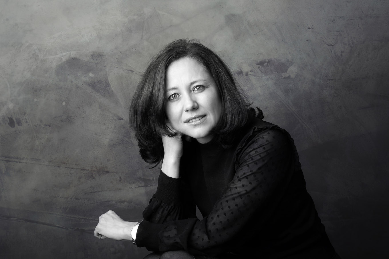 A portrait of a woman taken in a studio set up with backdrop and lighting equipment